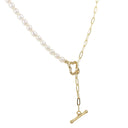 A delicate gold chain necklace featuring a strand of white freshwater pearls on one side and a gold paperclip chain with a heart-shaped clasp and a hanging toggle clasp on the other, shown against a solid white background.