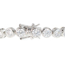 A close-up of a diamond tennis bracelet featuring round brilliant-cut diamonds set in a silver-colored metal, with the clasp mechanism visible in the center against a white background.
