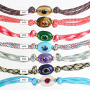 Seven braided cord bracelets with oval gemstone pendants are displayed vertically on a white background, each labeled with a number from #01 to #07. The cords come in various color combinations including brown, red, green, multicolor, light blue, purple, navy, and pastel blue.