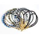 A bundle of woven rope necklaces with gold-tone metal clasps and hooks, displayed on a clean white background. The necklaces feature various patterns including black and white, blue and gold, green and brown, and black with small red details.