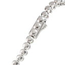A close-up of a silver tennis bracelet showing the polished round links and a rectangular clasp on a white background.