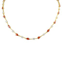A gold tennis necklace featuring marquise-cut orange-red gemstones and small round clear stones, displayed on a clean white background.