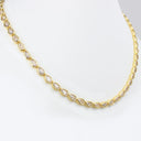 A gold tennis necklace featuring pear-cut clear gemstones in a continuous line, displayed on a white jewelry bust against a clean white background.