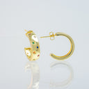 Gold hoop earrings with small colorful gemstone accents, shown on a clean light gray reflective surface.
