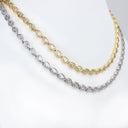 Two tennis necklaces displayed on a white mannequin bust, one in yellow gold and one in silver, both featuring teardrop-shaped clear stones.