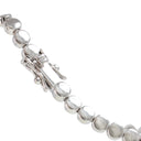 A close-up of a silver tennis bracelet featuring polished round beads and a lobster clasp, shown against a plain white background.
