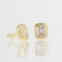 A pair of gold rectangular stud earrings with clear rectangular gemstones, shown on a reflective white surface against a light gray background.