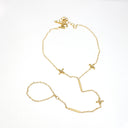A delicate gold chain necklace with a barbell centerpiece and three small cross charms, displayed on a clean white background.