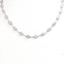 A silver-toned diamond necklace featuring a series of oval-cut diamonds set in a continuous chain, displayed against a clean white background.