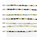 Seven strands of gold-plated cylindrical beads with various colored stone end beads are displayed vertically on a white background, labeled #01 to #07.