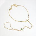 A delicate gold chain anklet featuring three small floral motifs with turquoise blue and brown gemstones, displayed on a clean white background.