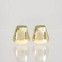 A pair of gold-toned, dome-shaped stud earrings with a polished, reflective finish, displayed on a light gray reflective surface.
