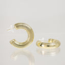 A pair of gold hoop earrings with a multi-layered, ribbed design, displayed on a reflective white surface against a light gray background.