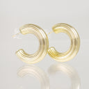 A pair of gold-toned, multi-strand crescent-shaped hoop earrings with clear butterfly backings, displayed on a reflective light gray surface.