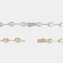 A close-up studio shot of a tennis bracelet showing three views: a full section of the silver-tone chain with oval clear stones, a close-up of the gold-tone chain with oval clear stones, and a close-up of the clasp.