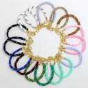 A set of 12 elastic wristlets with white stitching, arranged in a circular pattern on a white background. Each wristlet is attached to a gold metal chain and clasp.