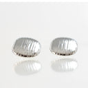 A pair of silver stud earrings with a textured, vertically ribbed oval design, displayed on a reflective white surface against a light gray background.