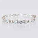 High Quality Fine‑Cut Oval Large and Small CZ Tennis Bracelet displayed in a circle on a reflective surface.