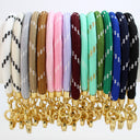A set of colorful braided strap keychains with gold-tone metal rings and clasps, shown in multiple colors including white, gray, brown, pink, lavender, burgundy, mint, green, blue, and black.