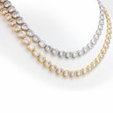 Two tennis-style necklaces with round clear gemstones in gold and silver settings, displayed on a white background.