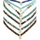 Five beaded necklaces arranged in a fan layout on a white background, each featuring gold-toned metal settings with clear gemstones and mixed stone beads in turquoise, green, brown, and blue tones.