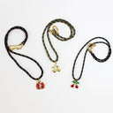 Three beaded cord necklaces with gold-tone pendants are arranged on a white background. The left necklace has red and gold beads with a red and gold cherry pendant.