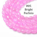 A close-up of bright fuchsia pink faceted oval beads arranged in a loop on a white background, with the text '#05 Bright Fuchsia' overlaid in the upper right.