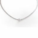 A silver tennis necklace with a single round-cut diamond pendant, displayed on a clean white background.