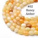 A close-up of multiple strands of faceted honey amber beads on a white background, with the text '#02 Honey Amber' printed in black on the upper right.