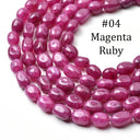 A close-up of a strand of polished oval gemstone beads in magenta-ruby color, coiled on a white background with the text '#04 Magenta Ruby' overlaid in the upper right.