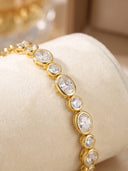 High Quality Fine‑Cut Oval Large and Small CZ Tennis Bracelet displayed close-up on a cream velvet fabric .