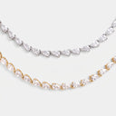Two tennis necklaces with pear-cut clear stones, one in silver-toned metal and one in yellow gold-toned metal, displayed against a light gray background.