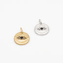 Two round evil eye pendant charms on a clean white background, one in yellow gold and one in silver, both featuring a black center stone and small clear stones around it.