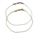 Three delicate chain bracelets in mixed gold and silver tones, arranged in overlapping loops on a plain white background. Each bracelet features a small clear gemstone accent and a lobster clasp.