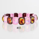 A pink and burgundy beaded bracelet with faceted amber and gold gemstones, shown on a reflective white surface with the text '#03' below.