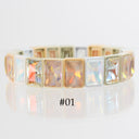 A gold-plated bracelet featuring rectangular iridescent cabochon crystals, shown on a reflective white surface with the text '#01' printed below.